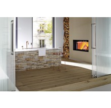 Badkamer met ligbad, open haard, stapel hout en houten vloer