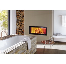 Badkamer met bad, open haard en stapel hout