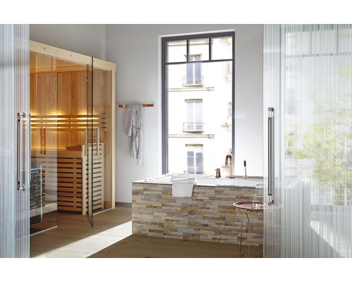 Badkamer met sauna, bad en raam met uitzicht op een gebouw