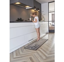 Keuken met keukenloper in houtdesign en jong meisje bij het fornuis