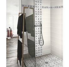 Inloopdouche met glazen wand, douchearmatuur en handdoekenrek in de badkamer.