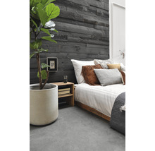 Slaapkamer met houten wandpanelen, bed en kamerplant in pot.