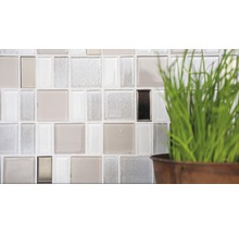 Detailopname van een wand met glazen mozaïektegels en decoratie