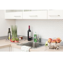 Keukenscène met gootsteen, kraan en diverse keukengerei op het aanrecht.