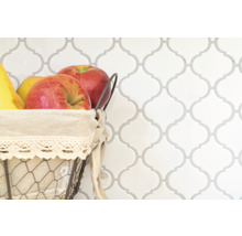 Decoratieve tegelwand met fruitmand op de voorgrond.