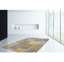 Modern tapijt met patchworkmotief in een lichte kamer.
