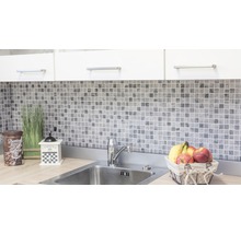 Keukenscène met mozaïektegels, spoelbak en decoratieve elementen.