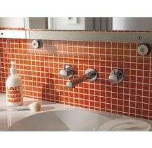 Badkamer met oranje tegels, wastafel en kranen