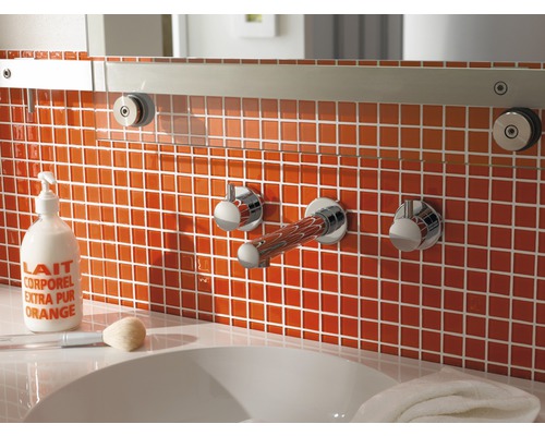 Badkamer met oranje tegels, wastafel en kranen