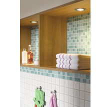 Badkamer met planken, handdoeken en tegels