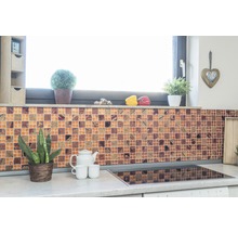 Keukenscène met mozaïektegelwand, planten en keukengerei op het aanrecht.