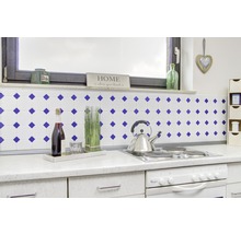 Keukenopstelling met tegels, kookplaat, oven, wijnfles en decoratie