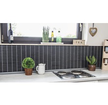Keukenscène met zwarte tegels, kookplaat, ramen en decoraties.
