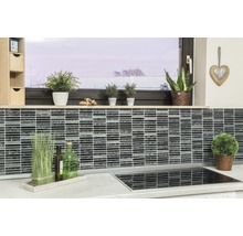 Keukenscène met mozaïektegels op de muur, planten en keukengerei op het aanrecht.
