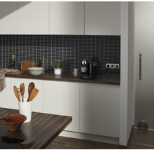 Lichte keuken met donker werkblad, donkere achterwandtegels en houten accenten.