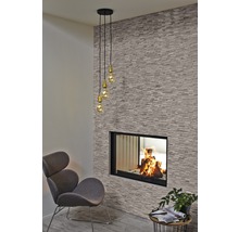 Woonkamer met open haard, fauteuil en hanglamp