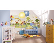Een kinderkamer met een Winnie de Poeh-behang, een blauw kinderbed, een commode en een gele ladekast.