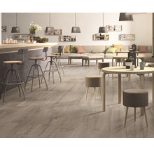 Interieur met houten vloer, barkrukken en tafels.