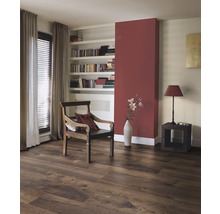 Woonkamer met laminaatvloer in houtlook, fauteuil en boekenplank