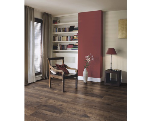 Woonkamer met laminaatvloer in houtlook, fauteuil en boekenplank