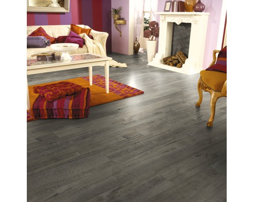 Woonkamer met laminaatvloer in houtlook, bank, vloerkleed en open haard
