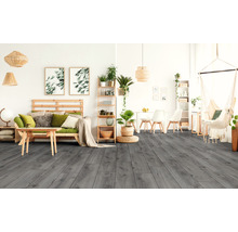Woonkamer met grijze houten vloerlook, houten meubels, hangplanten en hangstoel