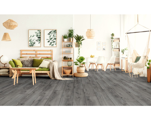 Woonkamer met grijze houten vloerlook, houten meubels, hangplanten en hangstoel