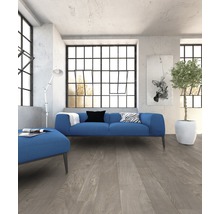 Woonkamer met blauwe bank, staande lamp en houten vloer