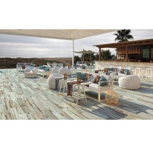 Buitenzitgedeelte met loungemeubels, houten vloer en uitzicht op zee