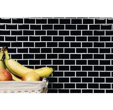 Wand met zwarte rechthoekige tegels en fruitmand