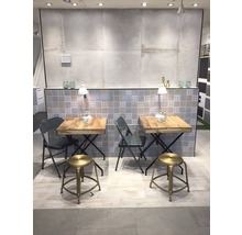 Showroom met twee tafels en zitplaatsen, betegelde achtergrond en verlichting.