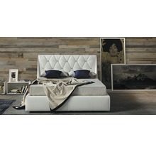 Bed met gecapitonneerd hoofdeinde, nachtkastje en schilderijen in de slaapkamer