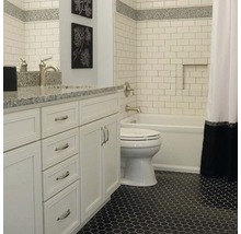 Badkamer met witte wastafel, toilet, bad en zeshoekige vloertegels