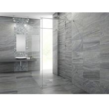Badkamer met grijze tegels, wastafel, spiegel en douche met glazen wand