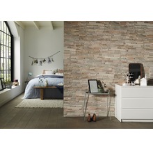 Decoratieve stenen muur in slaapkamer met bed en commode