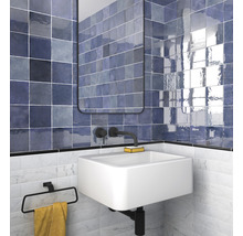 Badkamer met wastafel, spiegel en blauwe tegels