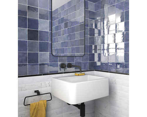 Badkamer met wastafel, spiegel en blauwe tegels