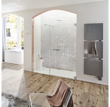 Lichte badkamer met douche, handdoekradiator, fauteuil en houten vloer