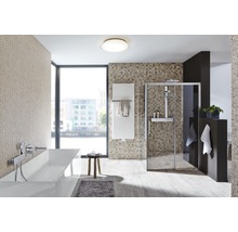 Lichte badkamer met bad, douche en radiator