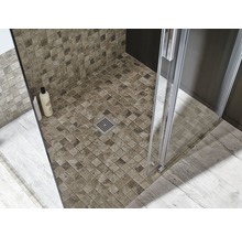 Detailopname van een douche met mozaïektegels, douchecabine en afvoer