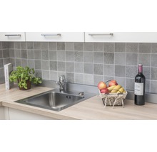 Keuken spoelbak met kraan op een aanrecht met betegelde achterwand