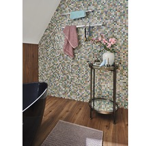 Badkamer met mozaïekmuur, bad, handdoeken en bijzettafel