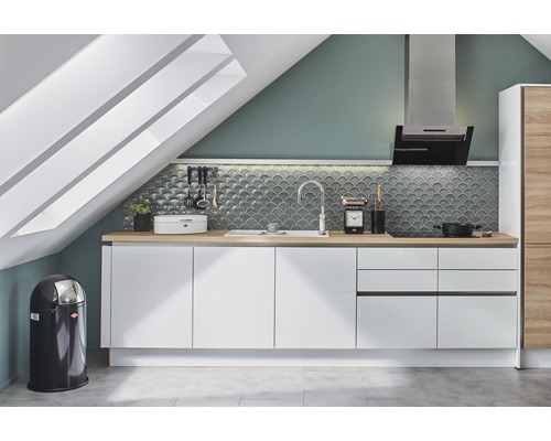 Keuken op een zolder met witte kasten en houten werkbladen