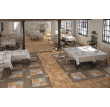 Interieur van een restaurant met tafels, stoelen en een vloer van tegels en hout.