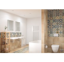 Lichte badkamer met wastafels, spiegels, bad, toilet en tegels met patronen