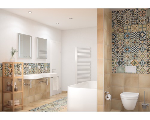 Lichte badkamer met wastafels, spiegels, bad, toilet en tegels met patronen