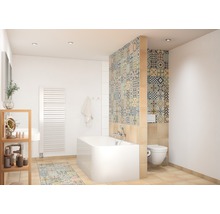 Badkamer met ligbad, toilet en tegels met motief