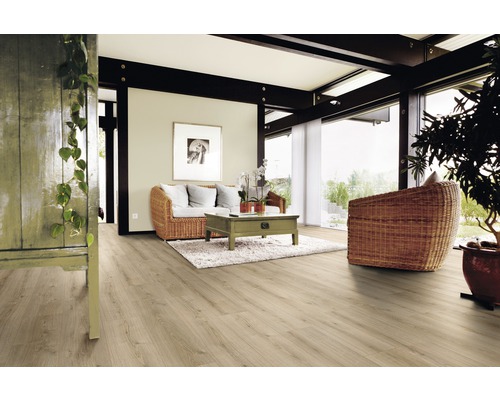 Lichte woonkamer met houten vloer, bank en stoel van vlechtwerk