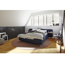 Slaapkamer met bed, tapijt en decoratieve elementen op een lichte zolder