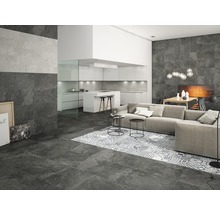Woonkamer met vloer- en wandtegels in steenlook, bank en open keuken